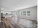 Open living room featuring lots of natural light, view to the kitchen, and wood-look flooring at 113 Fosters Glen Pl, Mooresville, NC 28115