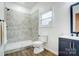 Modern bathroom featuring a tiled walk-in shower, contemporary fixtures, and a vanity with a black framed mirror at 113 Woodside Ave, Gastonia, NC 28054