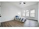 Bright bedroom with wood-look flooring, natural light through the window, and a ceiling fan at 113 Woodside Ave, Gastonia, NC 28054