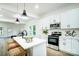Bright kitchen features modern appliances, white cabinetry, quartz countertops, and stylish pendant lighting over the island at 113 Woodside Ave, Gastonia, NC 28054