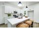 Well-lit kitchen featuring an island with seating, white cabinets, and stainless steel appliances at 113 Woodside Ave, Gastonia, NC 28054