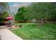Spacious backyard featuring lush greenery, a brick patio, outdoor fireplace and dining area, perfect for entertaining at 115 Stumpy Creek Rd, Mooresville, NC 28117