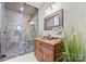 Rustic bathroom featuring a wood vanity, decorative mirror, stone tiling, and a glass-enclosed shower at 129 Hunts Landing Dr, Mooresville, NC 28117