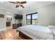 A bedroom features a hardwood floor, neutral wall color, view through window and ensuite bathroom at 129 Hunts Landing Dr, Mooresville, NC 28117