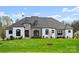 Beautiful home exterior with stone accents, manicured lawn, and professional landscaping at 129 Hunts Landing Dr, Mooresville, NC 28117