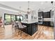 Open concept kitchen with island, stainless steel appliances, hardwood floors, island seating, and backyard view at 129 Hunts Landing Dr, Mooresville, NC 28117