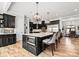 Open kitchen with large island, stainless steel appliances, hardwood floors and modern hanging lights at 129 Hunts Landing Dr, Mooresville, NC 28117
