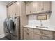 A modern laundry room features stainless steel appliances, ample cabinetry and counter space, and updated fixtures at 129 Hunts Landing Dr, Mooresville, NC 28117