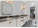 A modern main bathroom with dual sinks with dark marble countertops, white cabinets, and decorative wall lighting at 129 Hunts Landing Dr, Mooresville, NC 28117