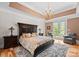 An elegant main bedroom featuring hardwood floors, chandelier, and french doors that lead to the outdoor patio at 129 Hunts Landing Dr, Mooresville, NC 28117
