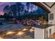A luxurious outdoor kitchen area complements a dazzling pool with stone waterfall feature during twilight at 129 Hunts Landing Dr, Mooresville, NC 28117