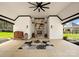 Enjoy this outdoor living space complete with fireplace, seating, and a neutral rug under a stylish ceiling fan at 129 Hunts Landing Dr, Mooresville, NC 28117