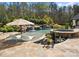 Backyard pool with waterfall, in-pool seating and spa, surrounded by stone patio at 129 Hunts Landing Dr, Mooresville, NC 28117