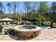Backyard pool and hot tub with waterfall feature and lush landscaping at 129 Hunts Landing Dr, Mooresville, NC 28117