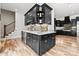 Entertainer's wet bar with beverage fridge, bar seating, custom cabinets, backsplash and hardwood floors at 129 Hunts Landing Dr, Mooresville, NC 28117