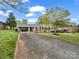 Long driveway leading to a brick ranch home with covered parking and lush green lawn at 1309 Briarcliff Rd, Shelby, NC 28152