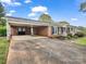 Brick ranch home with covered parking, a well-kept lawn, and a welcoming front porch at 1309 Briarcliff Rd, Shelby, NC 28152