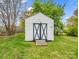 Exterior view of the storage shed with white paneling and double black doors on a well-maintained lawn at 1309 Briarcliff Rd, Shelby, NC 28152