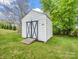White storage shed with contrasting black X doors and a small ramp on a green lawn at 1309 Briarcliff Rd, Shelby, NC 28152