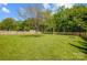 Spacious backyard with well-maintained lawn, mature trees, a swing set, and a storage shed at 13715 Sunrise View Dr, Charlotte, NC 28278