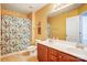 Bathroom with double vanity, matching faucets, neutral walls and colorful shower curtain at 13715 Sunrise View Dr, Charlotte, NC 28278