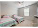 Bedroom featuring two twin beds, white walls, plush carpet, and natural light from a window at 13715 Sunrise View Dr, Charlotte, NC 28278