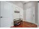 Entryway featuring hardwood floors, coat rack, bench with shoe storage, and multiple doors at 13715 Sunrise View Dr, Charlotte, NC 28278