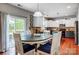 Eat-in kitchen featuring white cabinets, dark countertops, stainless appliances, and sliding glass door to the patio at 13715 Sunrise View Dr, Charlotte, NC 28278