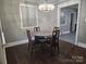 A quaint dining room featuring a round table, four chairs, elegant chandelier, and wood flooring at 148 Palaside Ne Dr, Concord, NC 28025
