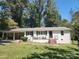 Charming brick home with a covered carport and welcoming front porch area and manicured yard at 148 Palaside Ne Dr, Concord, NC 28025