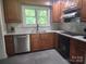 Well-lit kitchen featuring warm wood cabinetry, stainless steel appliances, and a window overlooking the backyard at 148 Palaside Ne Dr, Concord, NC 28025