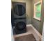 A cozy laundry area featuring a stacked washer and dryer unit near a window at 148 Palaside Ne Dr, Concord, NC 28025