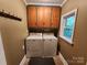 Laundry room with overhead cabinets, a window, and side by side washer and dryer at 148 Palaside Ne Dr, Concord, NC 28025