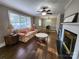 Comfortable living room with wood floors, fireplace, ceiling fan, and lots of light from large windows at 148 Palaside Ne Dr, Concord, NC 28025