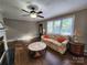 Cozy living room with hardwood floors, fireplace, lots of light from large windows, and ceiling fan at 148 Palaside Ne Dr, Concord, NC 28025