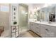 Elegant bathroom features a glass enclosed shower, double vanity with stone countertops and framed mirrors at 16004 Tulloch Rd, Charlotte, NC 28278