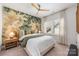Cozy bedroom featuring wallpaper with birds, a ceiling fan, large window, and a queen sized bed at 16004 Tulloch Rd, Charlotte, NC 28278