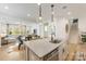 Bright kitchen island with pendant lights, stainless steel appliances and open floor plan to living and dining areas at 16004 Tulloch Rd, Charlotte, NC 28278