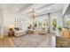 Spacious living room with large windows, a coffered ceiling, hardwood floors and an elegant chandelier at 16004 Tulloch Rd, Charlotte, NC 28278