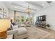 The sun-lit living room features a modern chandelier, a large window, and hardwood flooring at 16004 Tulloch Rd, Charlotte, NC 28278
