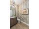 Stylish powder room with patterned wallpaper, marble countertop, and elegant lighting fixture at 16004 Tulloch Rd, Charlotte, NC 28278