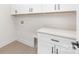 Laundry room features white cabinets, utility hookups, and vinyl floors at 1701 30Th Avenue Ne Ct, Hickory, NC 28601