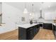 Bright, modern kitchen island featuring dark cabinets, bright white countertop and pendant lighting at 2008 St John St, Charlotte, NC 28216