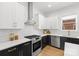 Modern kitchen design with stainless steel hood vent, oven, and white subway tile backsplash at 2008 St John St, Charlotte, NC 28216