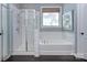 Bright bathroom with a glass-enclosed shower, soaking tub, and tile surround at 2030 Bosna Ln, Fort Mill, SC 29715
