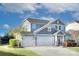 Attractive two-story home featuring three-car garage, manicured lawn, and beautiful blue siding at 2030 Bosna Ln, Fort Mill, SC 29715