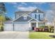 Charming two-story home boasts a well-manicured lawn, three-car garage, and beautiful blue siding at 2030 Bosna Ln, Fort Mill, SC 29715