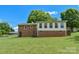 Expansive backyard view of brick home featuring a sunroom and well-maintained lawn at 205 Cooke Cir, Kings Mountain, NC 28086