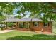 Lovely brick home features a welcoming porch, stylish black shutters, and lush front lawn at 205 Cooke Cir, Kings Mountain, NC 28086