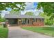 Charming brick home with a cozy front porch, manicured lawn, and convenient carport at 205 Cooke Cir, Kings Mountain, NC 28086